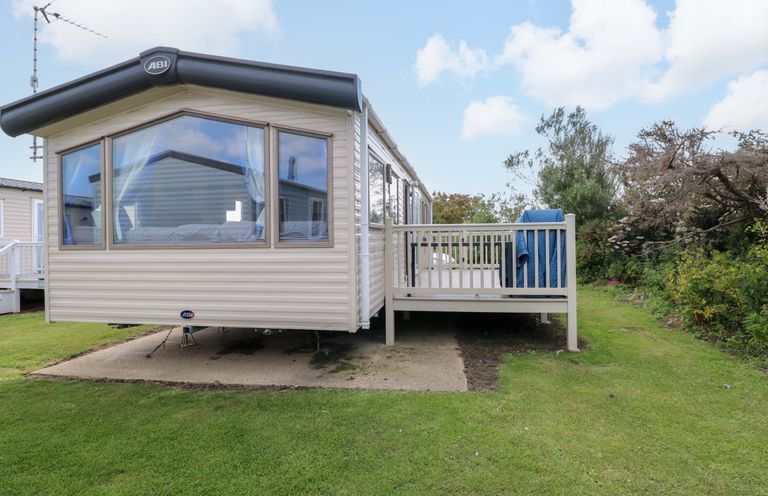 A static caravan with a deck in an outdoor area at PK Sunset View in Corton
