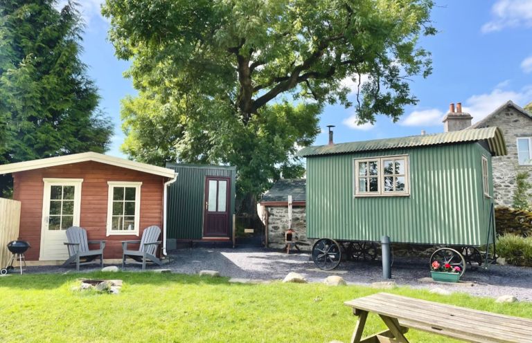 An outdoor area with a wooden cabin and a shepherd's hut at Cwt Tyddyn Shepherd's Hut Cefn Brith near Cerrigydrudion