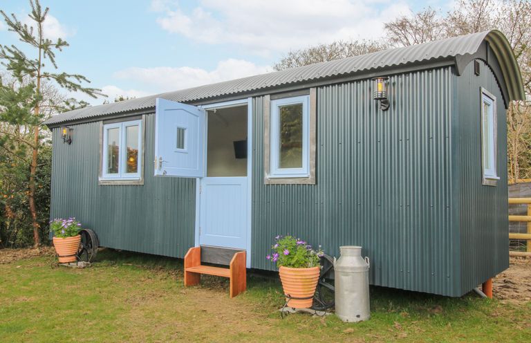 A shelter with blue door and windows set outside at Skye in Clee Hill