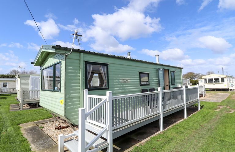 A green caravan with a deck and steps at The Seafront Cosy Caravan in Ingoldmells