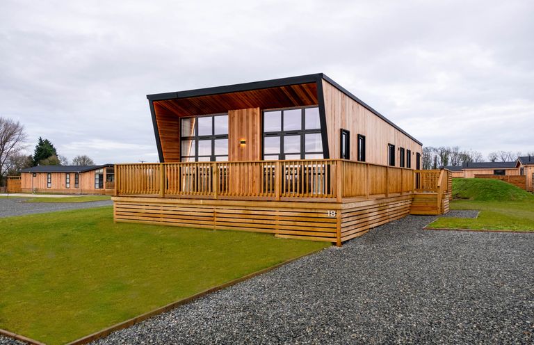 A lodge with decking and large windows at Exclusive Tempest Spa in Grimsby