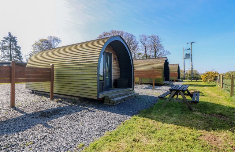A view of wooden cabins with picnic table at Bron Eifion Pod 1 in Criccieth