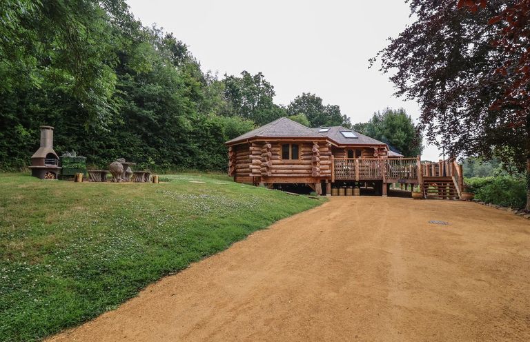 A log cabin with a deck and outdoor seating at Copper Suite in Chulmleigh