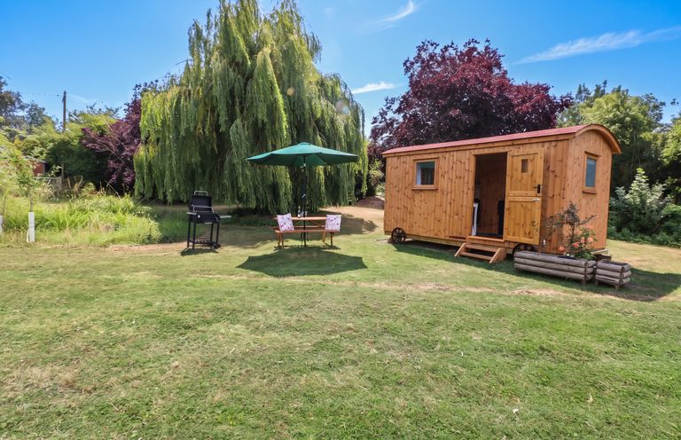 An outdoor setting with a wooden shed and seating area at Laurel in Welney near Littleport