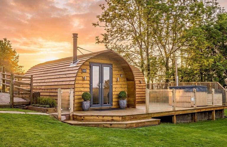 A wooden cabin with a deck and hot tub at The Lodge at Brambles Farm Sleeps 4 Hot Tub in Leek