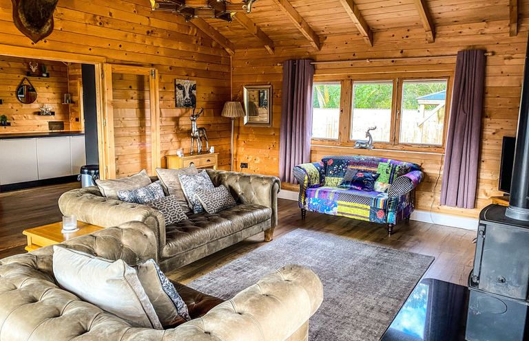 A living room with a sofa and armchair at The Cabin in The Woods