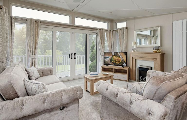 A living room with a sofa and television at 2Br Lodge Pool Fireplace PetsOK Parking in Goonhavern
