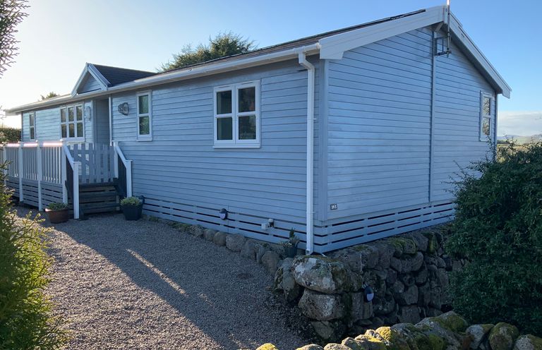 Exterior view of a wooden lodge at Holly Blue - Cosy wooden lodge, Kippford near Dalbeattie