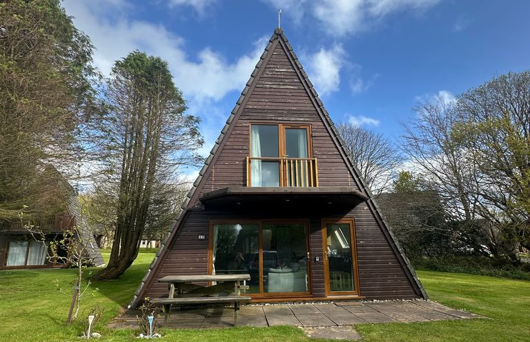 A house with a balcony and patio furniture at Lodge 22, Bodmin Holiday Park, Cornwall